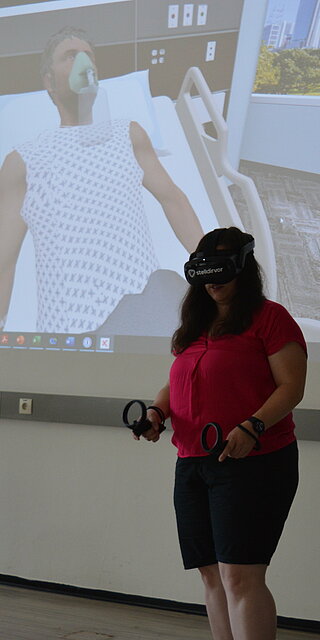 Andrea Sattler versorgt einen fiktiven Patienten im virtuellen Krankenzimmer. Foto: Tanja Rexhepaj/OTH Regensburg